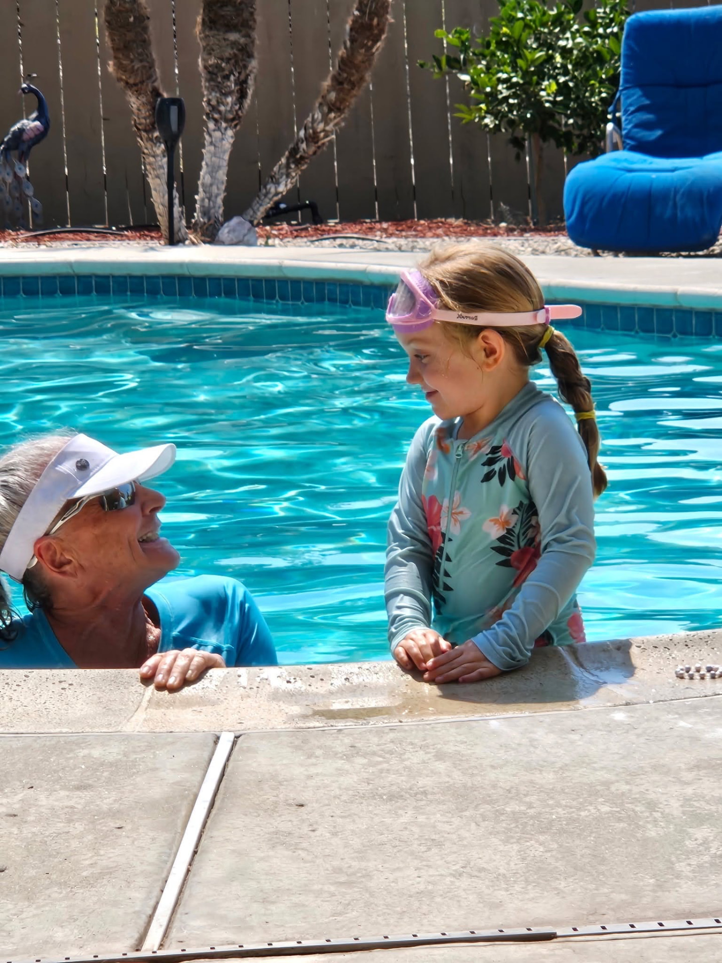 Deanna encouraging a young swimmer at the edge of the pool